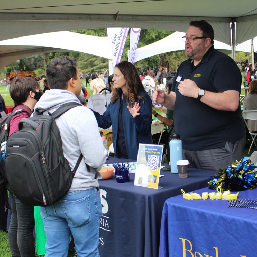 Students interacting with school representatives at the Grad and Law School Fair